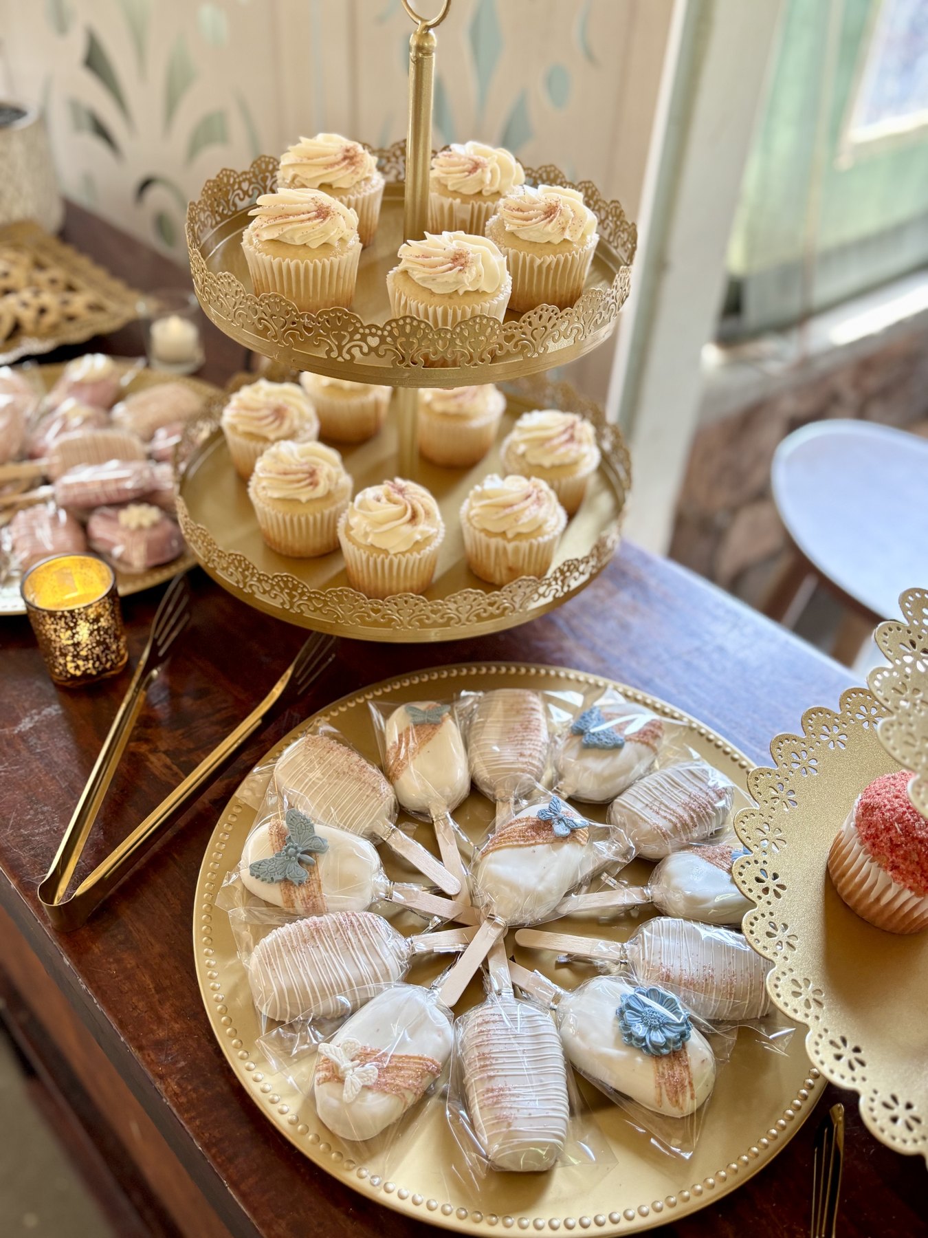 Gold dessert display with cupcakes and wrapped cookies