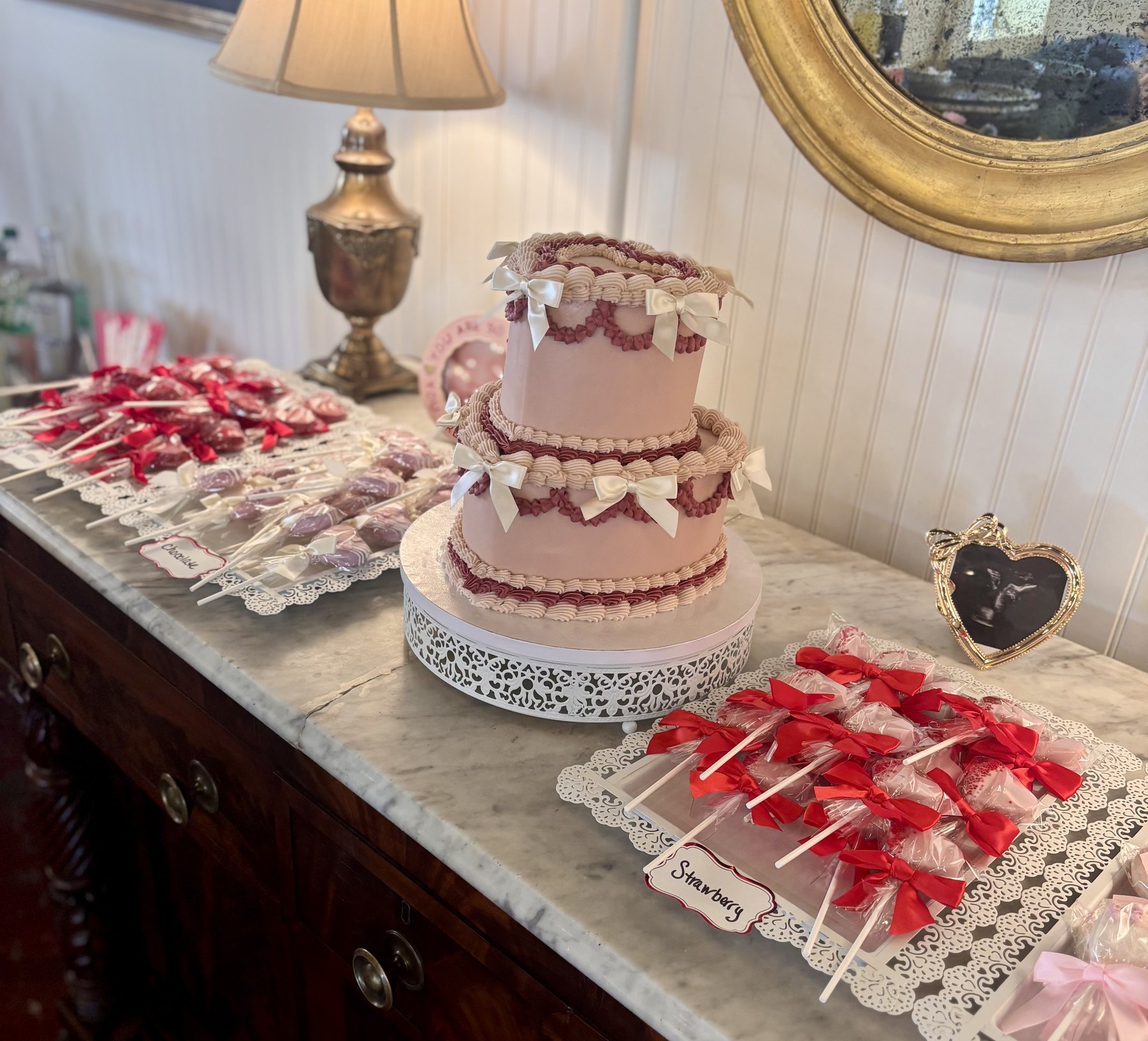 Pink dessert table with cake pops and custom cake